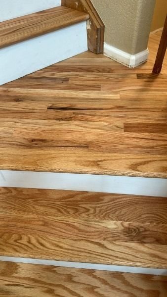 Refinished hardwood flooring restored in a staircase by Floors By Tomorrow